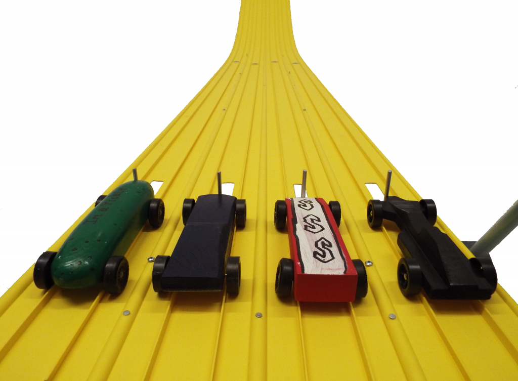 Pinewood derby cars lined up across the lanes at the start of a Derby Magic track
